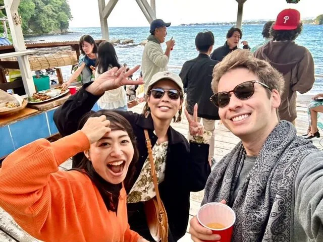 海辺で複数人が笑顔で写るセルフィー