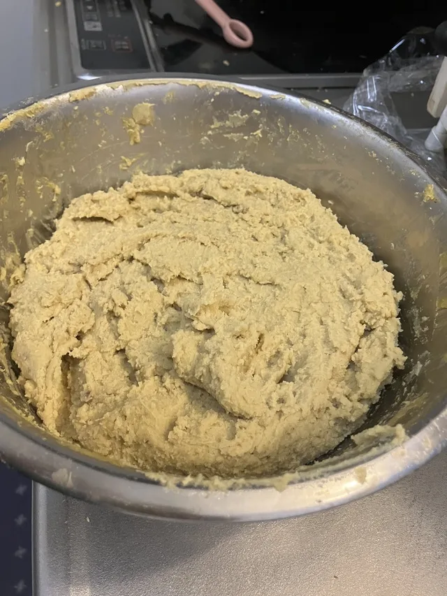 大きな金属製のボウルに入った、黄色っぽいペースト状の食品。