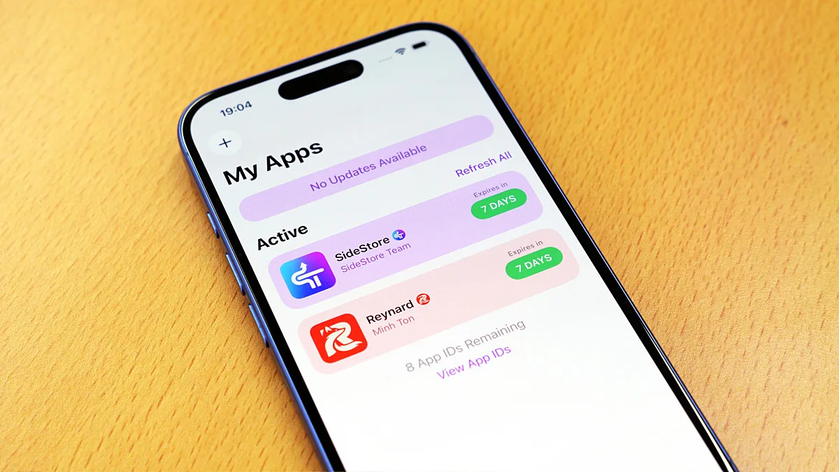 木目のテーブルに置かれたスマートフォンの画面に、インストール済みアプリが表示されている