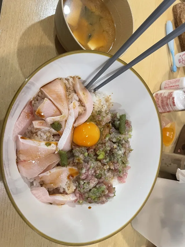 魚の刺身とたたき、卵黄が乗った丼と味噌汁